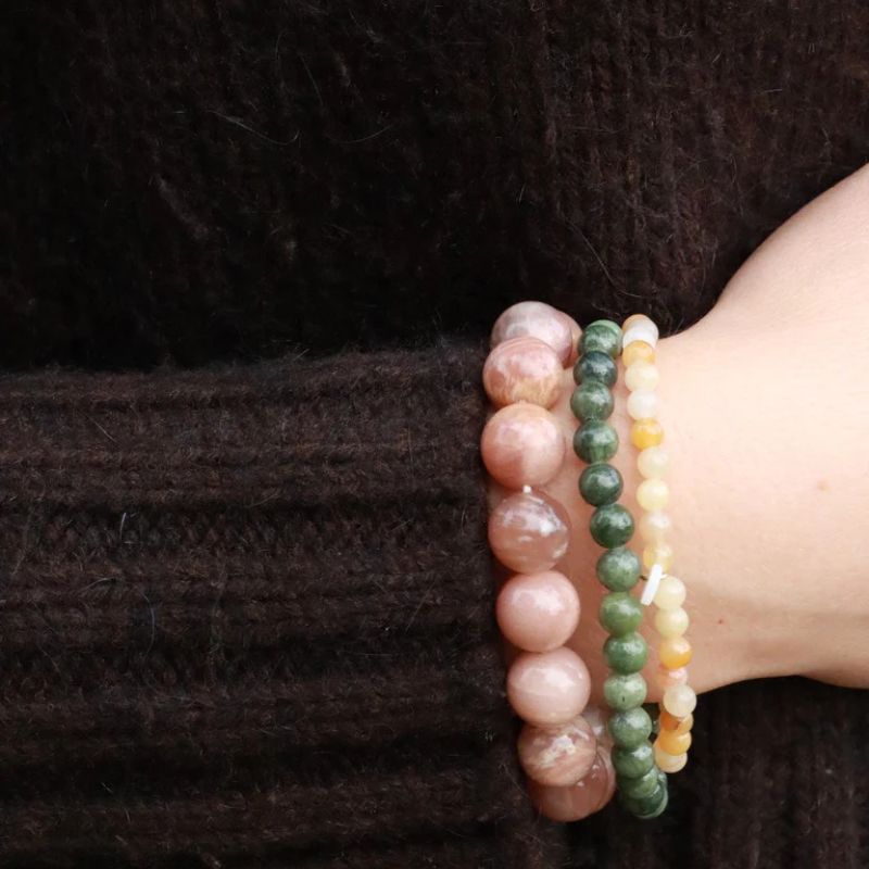 Gouden stretch armband met grote zonnesteen kralen gedragen als Scandinavisch sieraad.